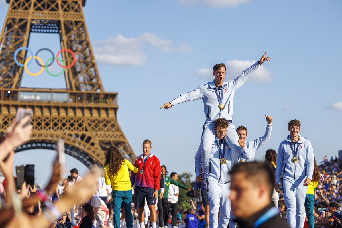 Olympic rowing gold medallists celebrating in front of the Eiffel Tower and the Olympic rings, Paris 2024